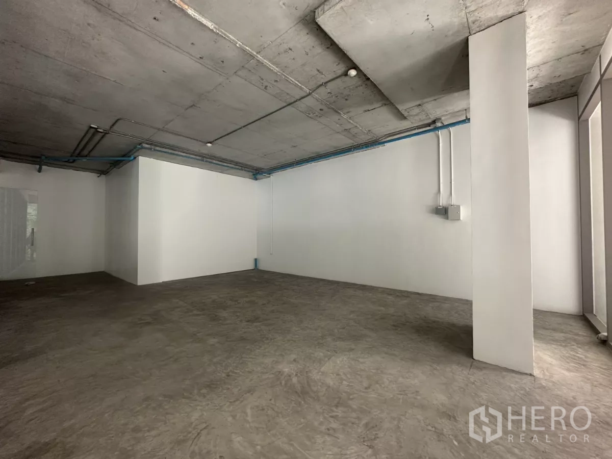 Retail Space for rent - Back section of the unit with concrete floors and visible conduits ready for MEP installation.
