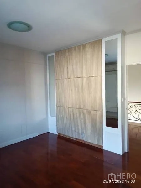 Detached House for sale in Prawet, Bangkok - Bedroom corner with decorative slatted wall panel and mirrors.