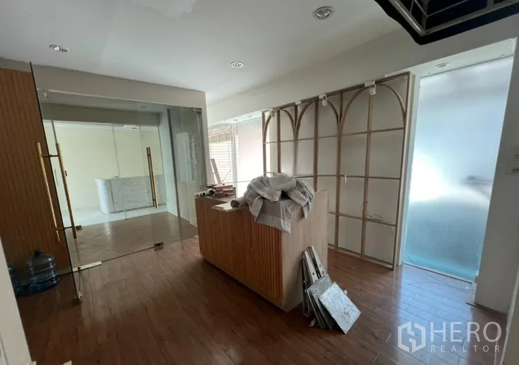 Retail Space for rent - Retail room under renovation with a wood counter and arched feature wall.