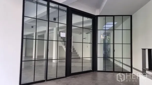 Shophouse for rent in Khlong Toei, Bangkok - Black-framed glass partition doors creating a flexible office or meeting room inside the shophouse.