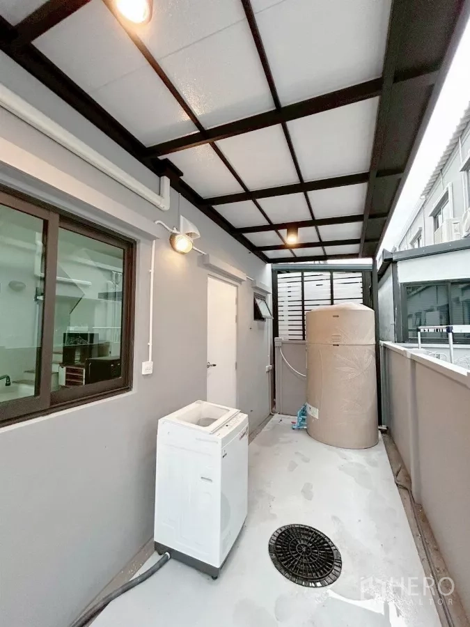 Townhouse for rent in Bang Phli, Samut Prakan - Wider view of covered service yard with water tank and lighting.