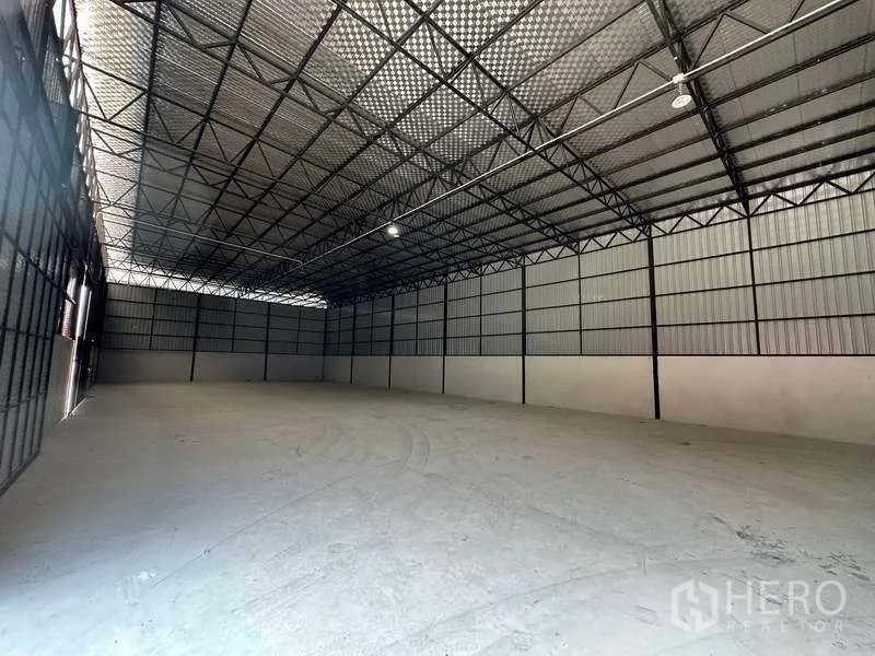Warehouse for rent in Khlong Sam Wa, Bangkok - Empty warehouse space showing steel frame, high ceiling and reinforced concrete flooring.