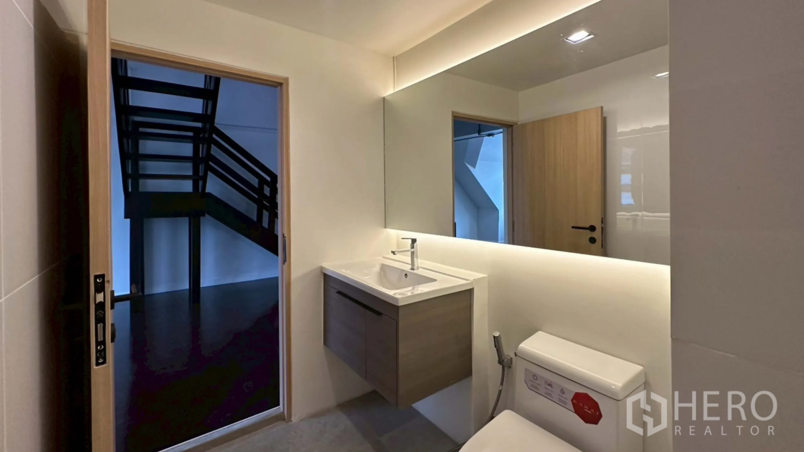 带办公室的家 出租在Watthana, Bangkok - 带悬空洗手台的卫浴，可见门外楼梯景象。