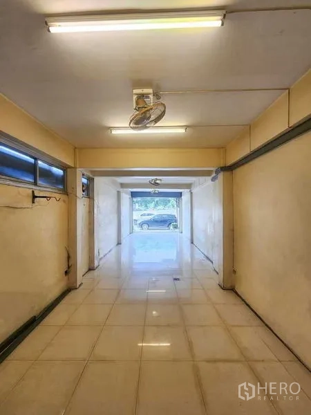 Shophouse for rent in Bang Rak, Bangkok - Open-plan ground-floor retail space with tiled flooring and glass frontage to the street.