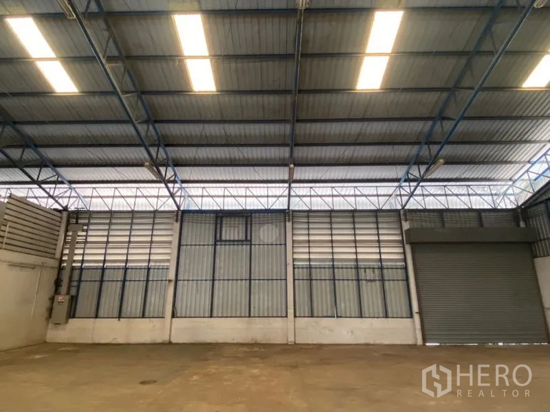 Factory for rent in Lat Lum Kaeo, Pathum Thani - Warehouse wall panels with lighting and one roller shutter door.