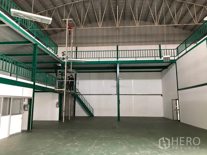 Factory for rent in Lam Luk Ka, Pathum Thani - Mezzanine platform with goods lift and green steel railings inside the factory.