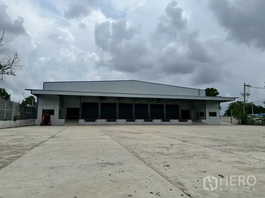 货栈 出租在Si Racha, Chon Buri - 诗拉差独栋仓库外观，宽阔混凝土前场与带顶装卸月台