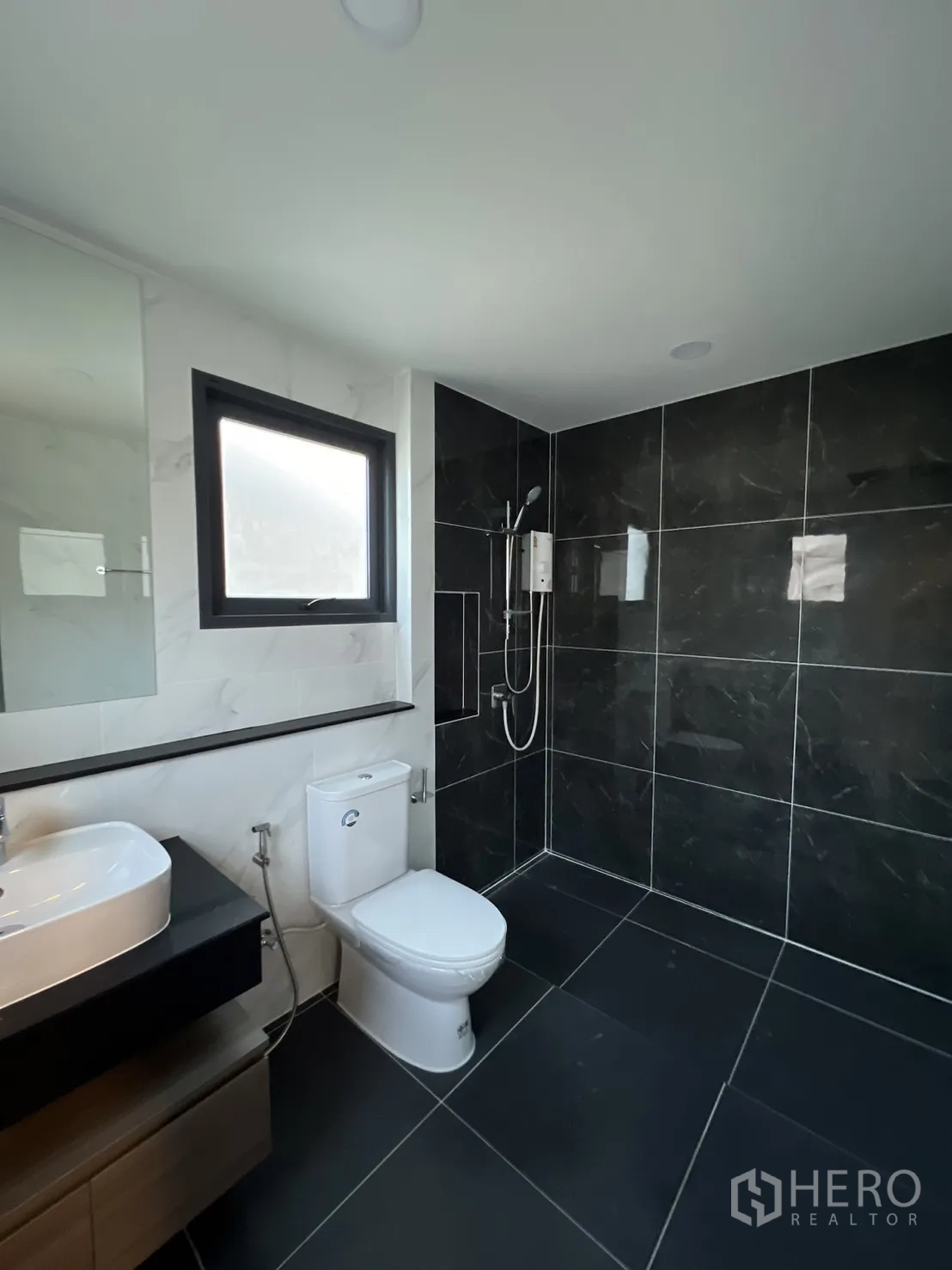 Detached House for rent or sale in Bang Phli, Samut Prakan - Contemporary bathroom with black-and-white tiles and glass shower.