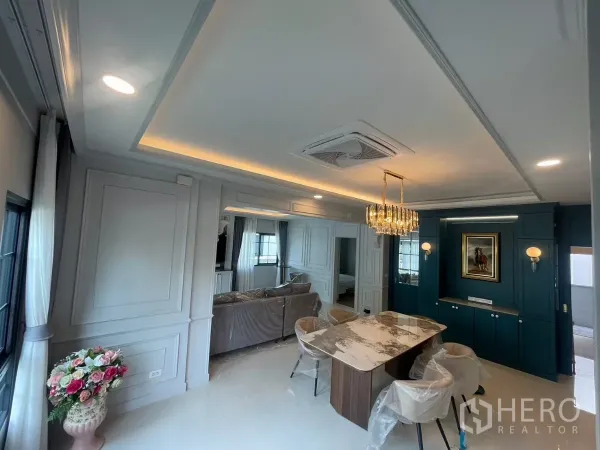 Detached House for rent in Bang Phli, Samut Prakan - Dining area with statement chandelier, paneled walls and built-in cabinetry.