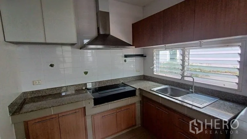 Detached House for sale in Prawet, Bangkok - U-shaped kitchen with granite countertops, range hood and upper-lower cabinets.