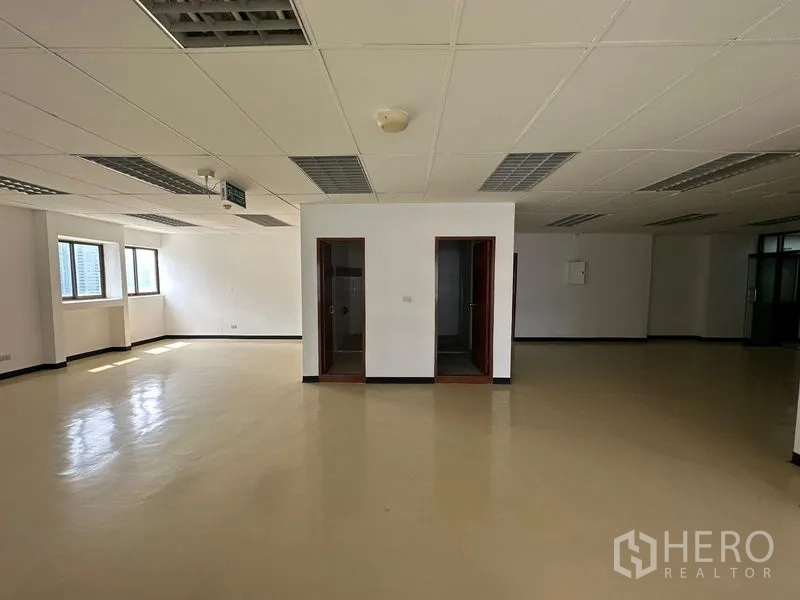 Office Space for rent in Pathum Wan, Bangkok - Spacious open-plan office with drop ceiling, fluorescent lighting, two internal rooms and light-colored flooring.