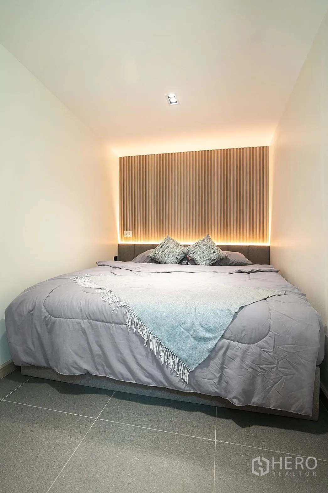 Detached House for rent in Huai Khwang, Bangkok - Compact bedroom with low ceiling, paneled headboard and soft lights.