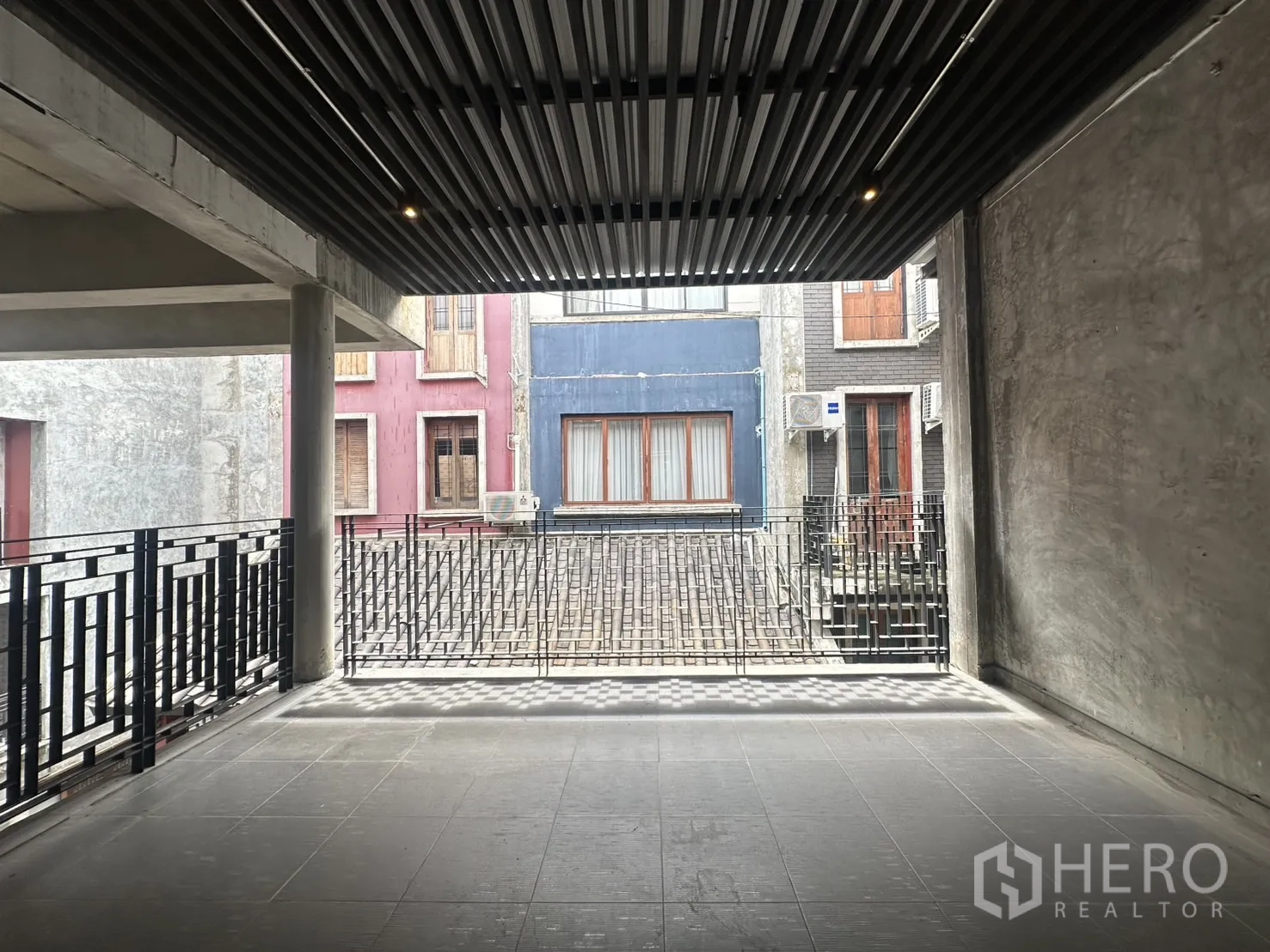 Home Office for rent in Pathum Wan, Bangkok - Covered terrace passage with slatted metal ceiling and railings between buildings.