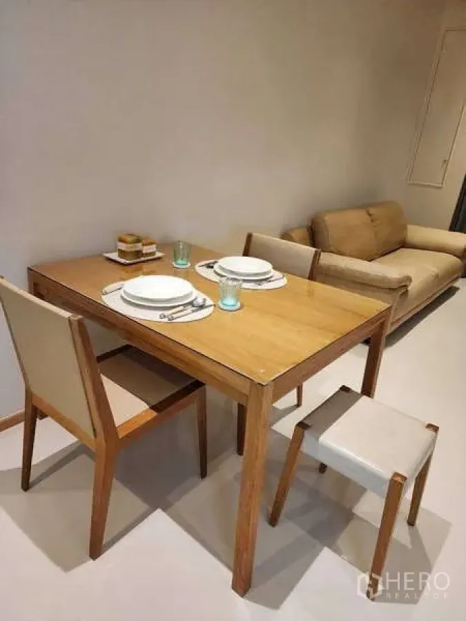 Condominium for rent - Open-plan dining and living area with wooden table set and a comfy sofa.