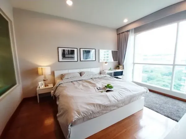 Condominium for rent in Pathum Wan, Bangkok - Spacious master bedroom with king bed, bedside tables and large window with green city views.