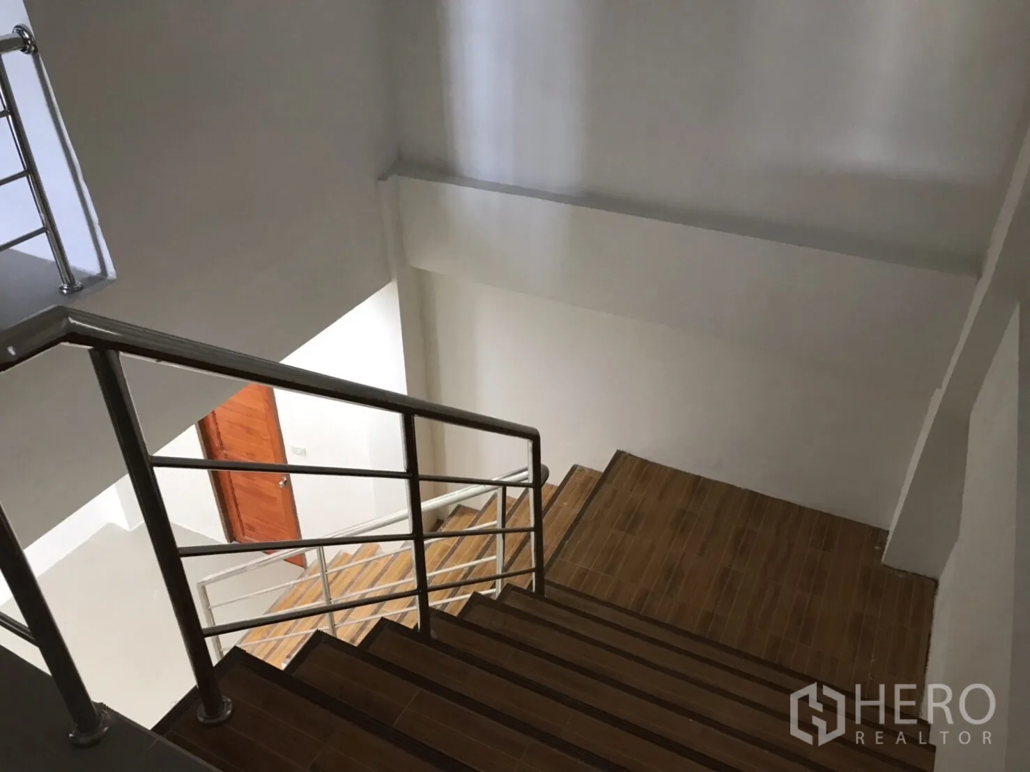 Factory for rent or sale in Mueang Samut Sakhon, Samut Sakhon - Interior staircase with stainless handrail and wood-look steps in the office block.