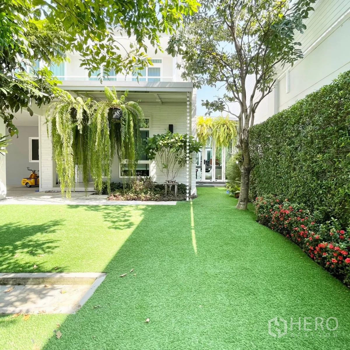 Detached House for rent or sale in Prawet, Bangkok - Landscaped side garden with artificial lawn, hedges, trees and flower border.