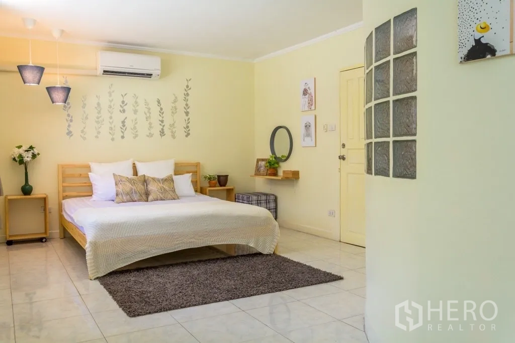 Home Office for rent in Suan Luang, Bangkok - Spacious bedroom with bed, tile floors and soft lighting.