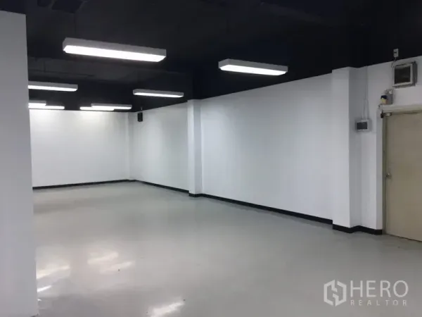 Office Space for rent in Huai Khwang, Bangkok - Clean open workspace with smooth flooring, black exposed ceiling and rectangular lights.