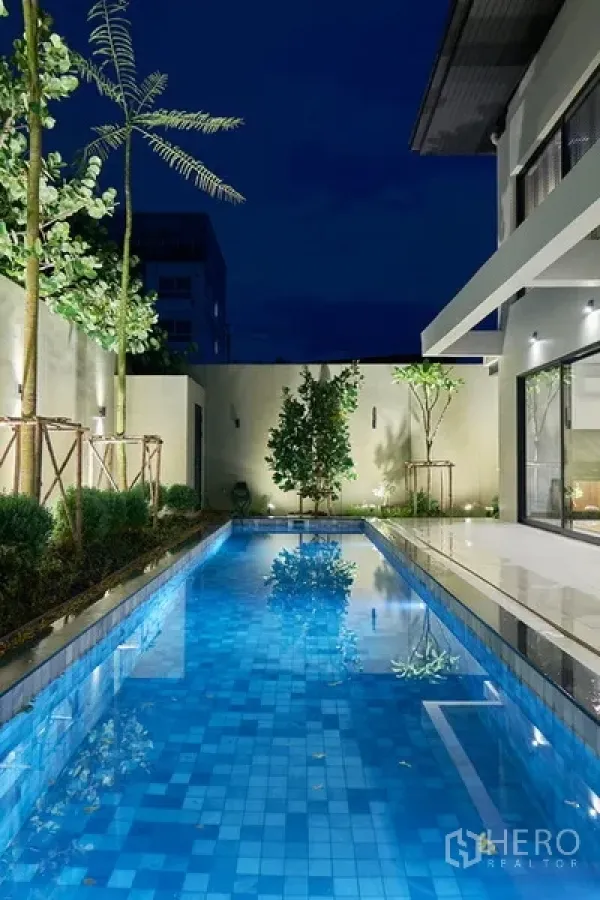独立式住宅 出租在Watthana, Bangkok - 夜景泳池，花园灯光与现代围墙映衬