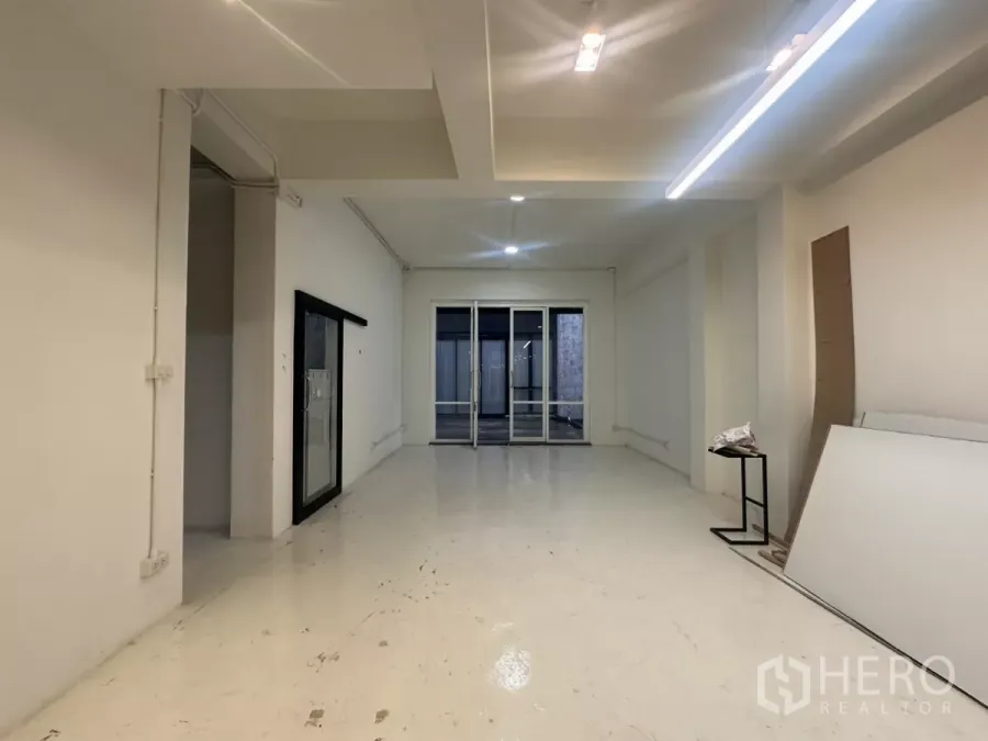 Home Office for rent in Pathum Wan, Bangkok - Open-plan home office room with white walls, ceiling lights, polished floor and rear glass doors.