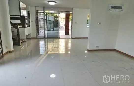 Office Space for rent in Chatuchak, Bangkok - Ground-floor open-plan office with white tile floors, glass sliding doors and wall-mounted air conditioner.