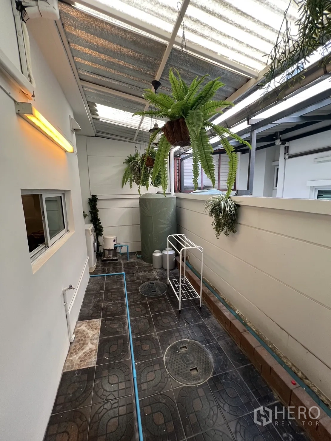 联排别墅 for rent in Suan Luang, Bangkok - 带顶棚的后院功能区，悬挂绿植与地砖铺设。
