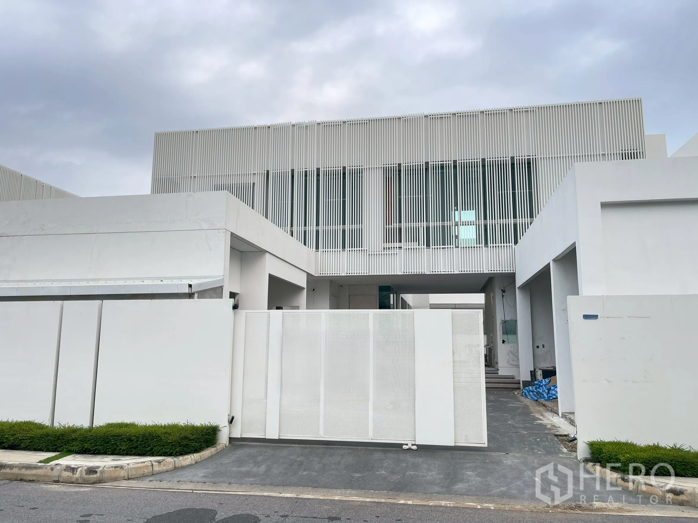Detached House for sale in Bang Phli, Samut Prakan - Modern two-storey white facade with vertical slats and sliding gate.