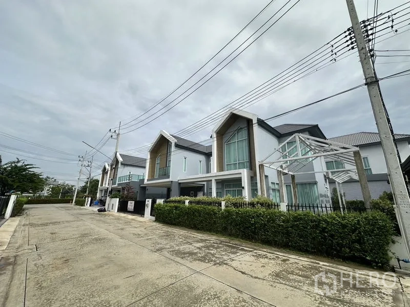 Detached House for sale in Lam Luk Ka, Pathum Thani - Quiet residential street lined with contemporary detached houses and sidewalks.
