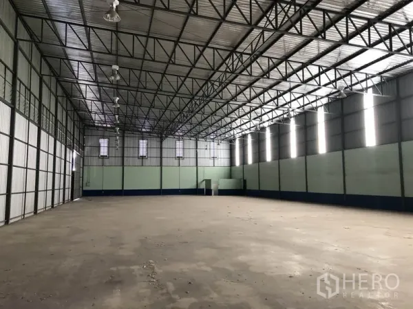 货栈 出租在Pathum Thani - 仓库内部空间开阔，钢结构高屋顶与混凝土地面清晰可见。