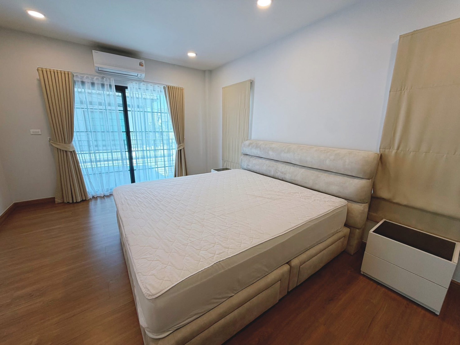 Detached House for rent in Bang Phli, Samut Prakan - Bedroom with sliding door to balcony, sheer curtains and wall-mounted air conditioner.