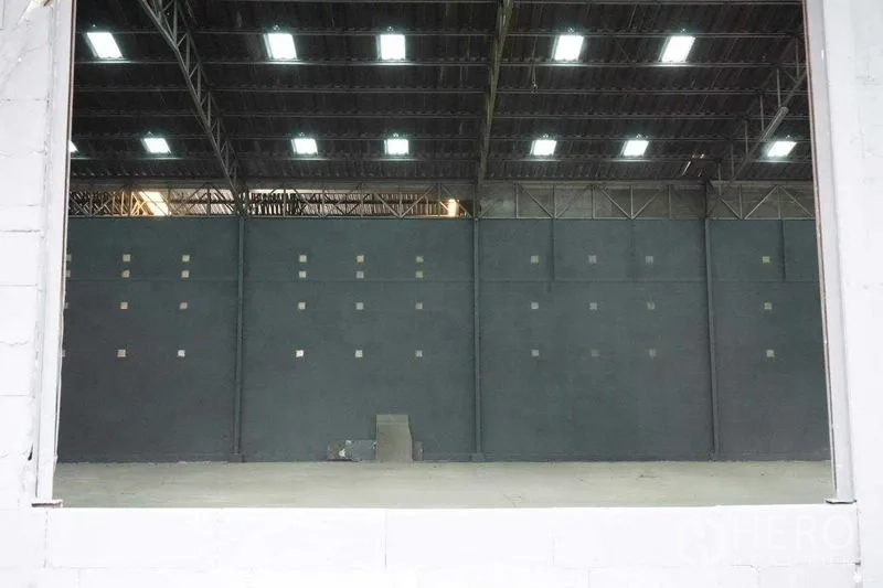 Warehouse for rent in Phra Nakhon Si Ayutthaya - Interior looking toward the entrance showing steel trusses and lighting.