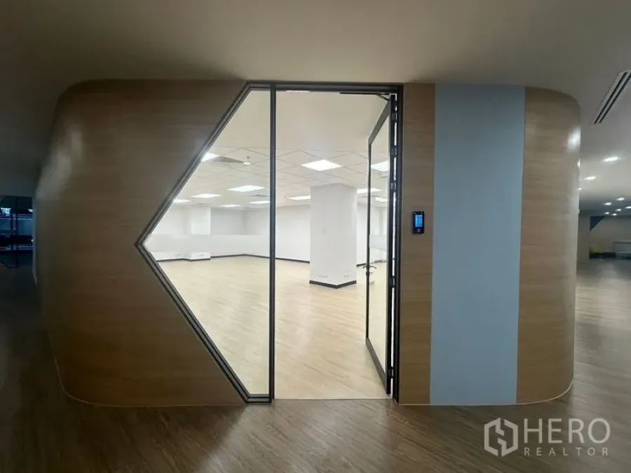 Office Space for rent in Chatuchak, Bangkok - Access-controlled entry to an office with full-height glass door and curved timber feature wall.