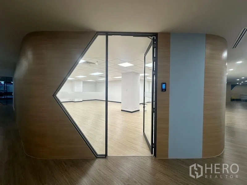 Office Space for rent in Chatuchak, Bangkok - Access-controlled entry to an office with full-height glass door and curved timber feature wall.