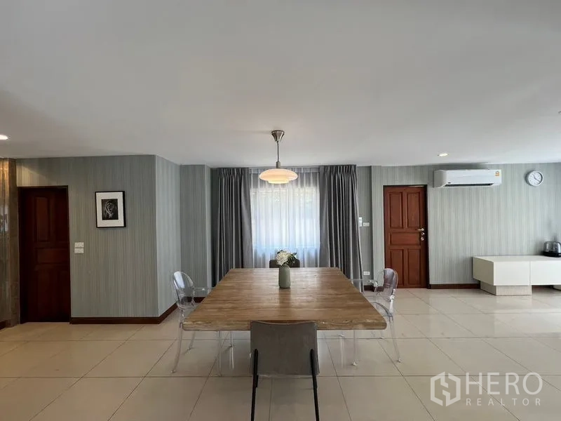 Detached House for sale in Mueang Pathum Thani, Pathum Thani - Dining zone with wooden table for six, pendant light and wall-mounted air-conditioner.