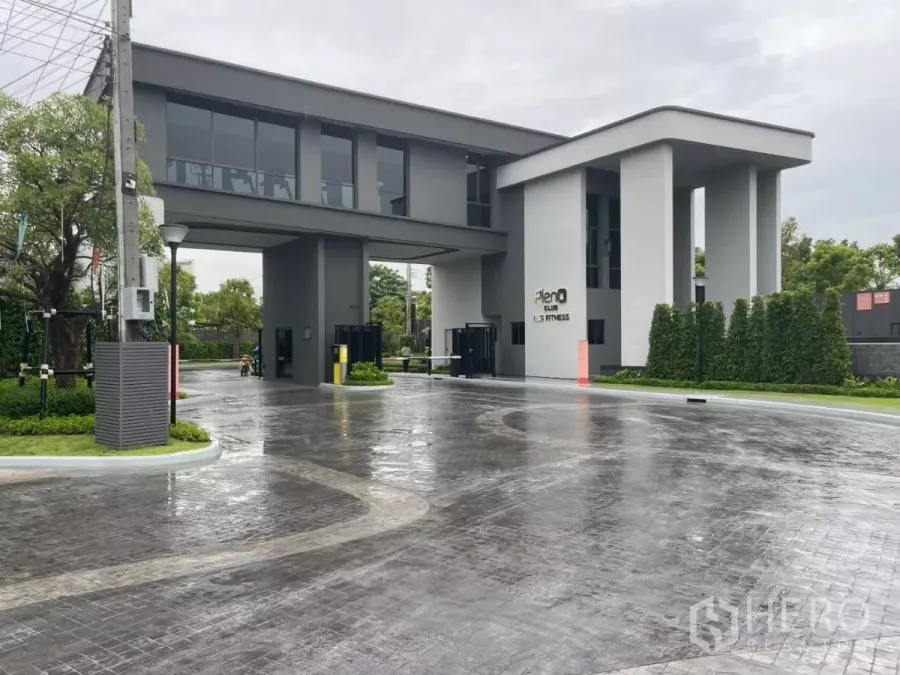 联排别墅 出租在Samut Prakan - 现代化会所与入口岗亭，墙面写有 Pleno Club Fitness。