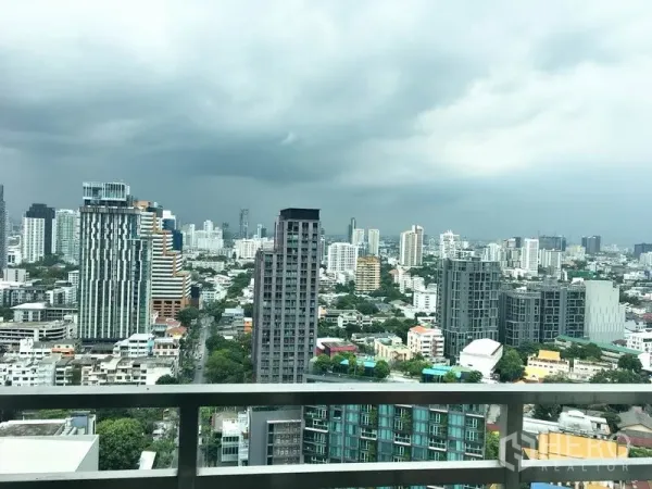 Condominium for rent in Khlong Toei, Bangkok - High-floor balcony view of the Ekkamai–Thonglor skyline under a cloudy sky.