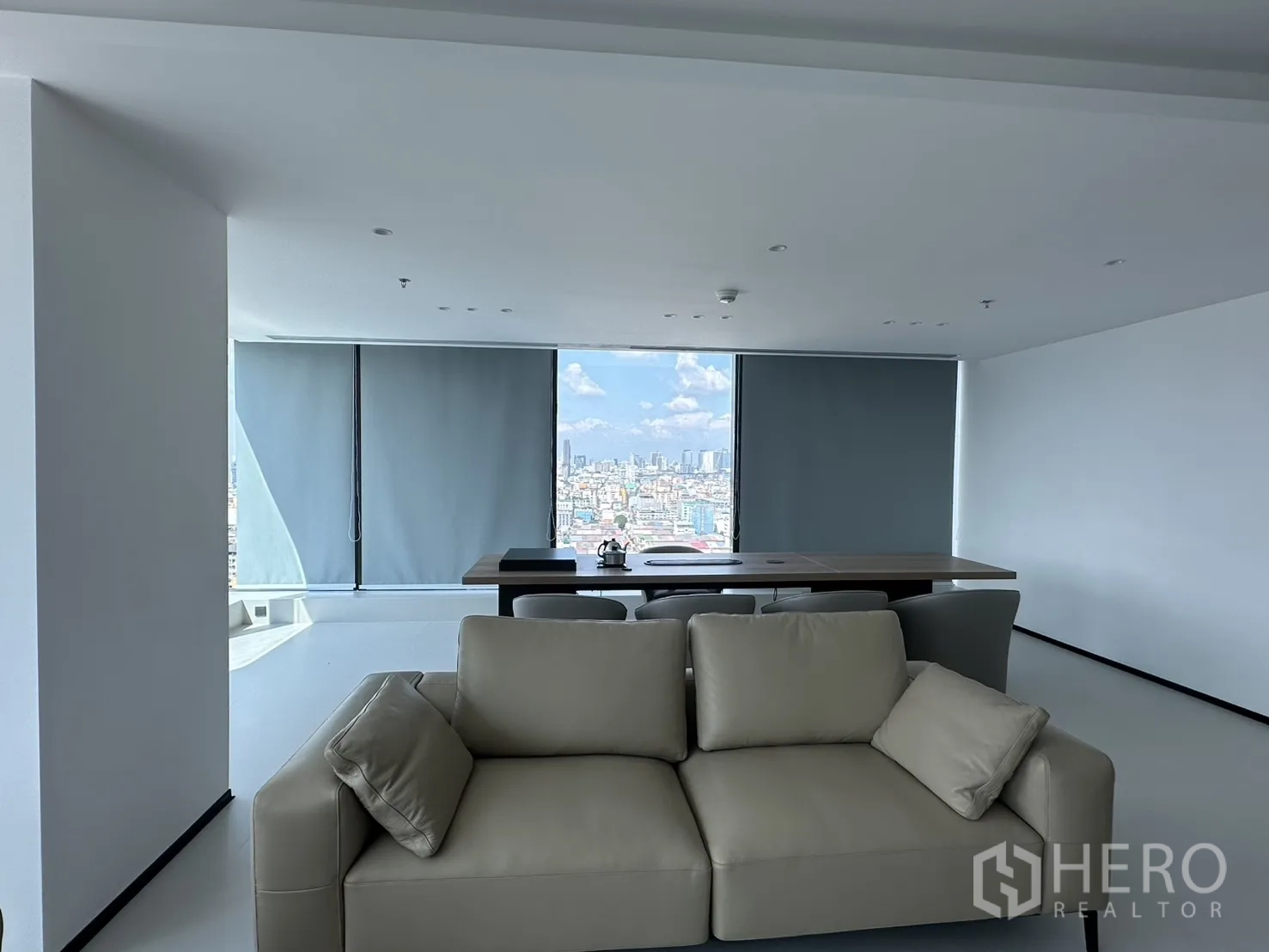 Office Space for rent in Din Daeng, Bangkok - Sofa seating facing a conference table with tall windows fitted with blinds.