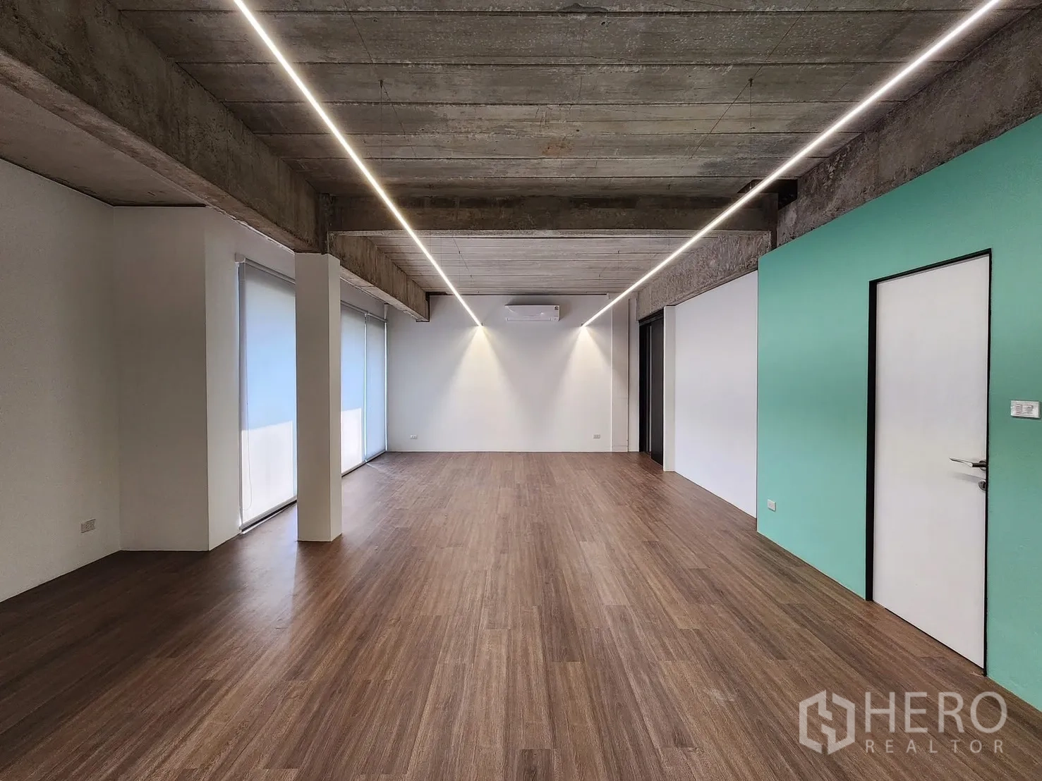 Home Office for rent in Chatuchak, Bangkok - Spacious room with wood floors, mint feature wall, roller blinds, and air-conditioning.