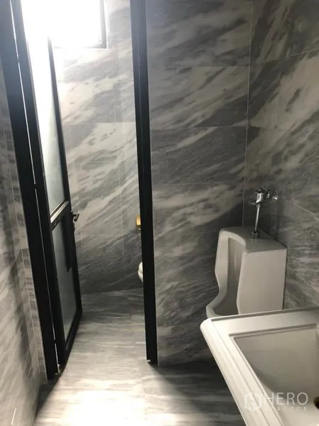 Retail Space for rent in Khlong Toei, Bangkok - Marble-tiled restroom with urinal and sink inside the retail property.