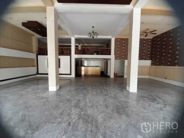 Shophouse for rent in Huai Khwang, Bangkok - Spacious open-plan shophouse interior with high ceiling, pillars, mezzanine, chandelier and reception counter.