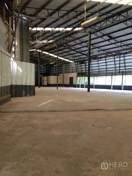 Warehouse for rent in Bang Khen, Bangkok - Open-plan storage hall with high ceiling, steel columns and smooth concrete flooring.