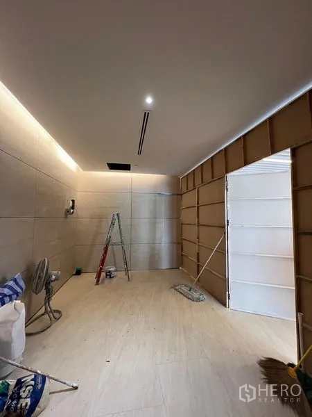 Retail Space for rent in Pathum Wan, Bangkok - Compact retail unit under renovation with beige tiled floor, recessed lighting and a ladder.