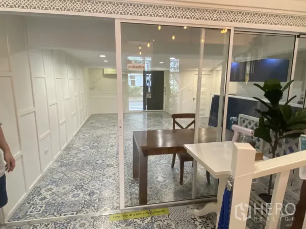 Retail Space for rent in Bang Rak, Bangkok - Glass sliding partition opening to an open-plan retail area with patterned tiles and white walls.