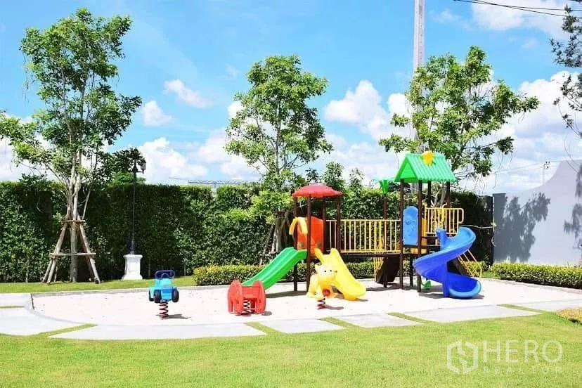 Detached House for rent in Prawet, Bangkok - Community playground with colorful slides and spring riders set amid lawns and trees.