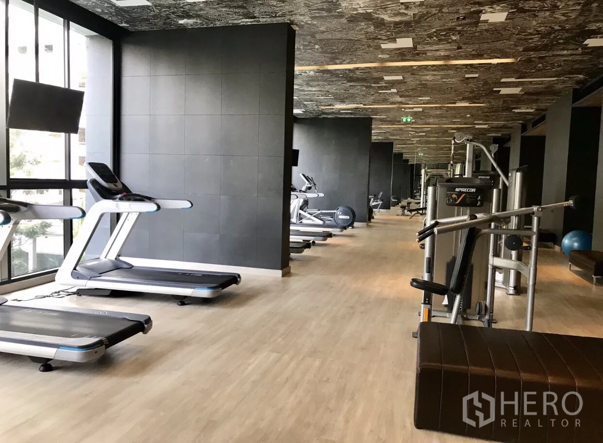 Condominium for rent in Pathum Wan, Bangkok - Fully equipped fitness center with treadmills, weight machines and floor-to-ceiling windows.