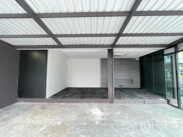 Office Space for rent in Bang Na, Bangkok - Raised carpeted workspace with ceiling cassette air-conditioner and grey feature wall behind glass.