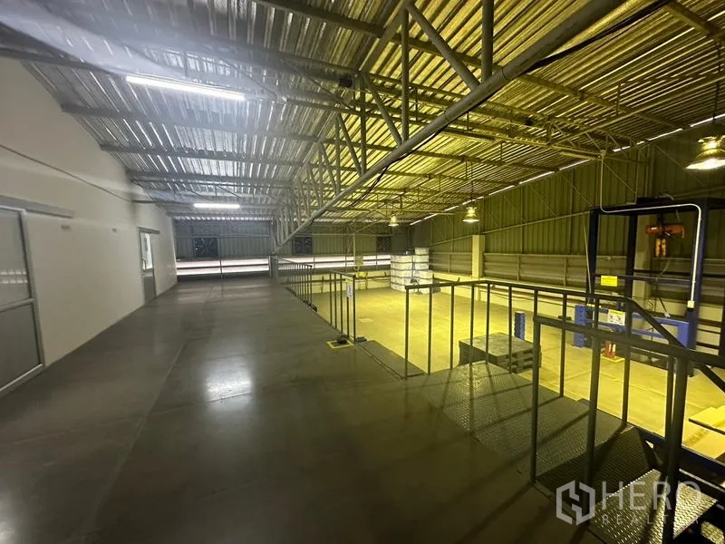 Warehouse for rent or sale in Lam Luk Ka, Pathum Thani - Mezzanine walkway overlooking a high‑roof warehouse with steel trusses and lighting.
