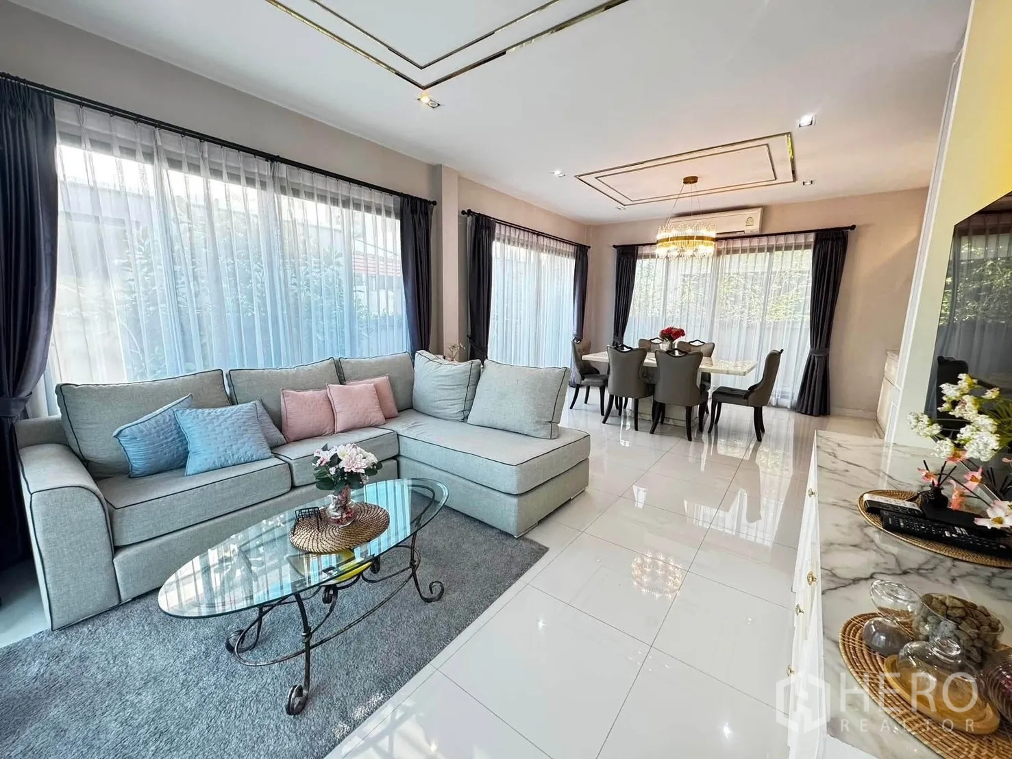 บ้านเดี่ยว for rent in Saphan Sung, Bangkok - ห้องนั่งเล่นโอเพ่นสเปซพร้อมโซฟา L โต๊ะกลางกระจก และหน้าต่างบานใหญ่.