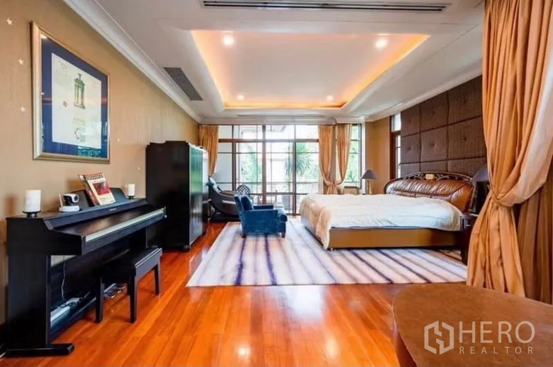 Detached House for rent in Khlong Toei, Bangkok - Spacious master bedroom with polished wood floors, tray ceiling, large windows and a piano seating area.